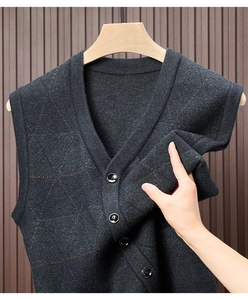 Detail view of dark grey V-neck knit vest with diamond texture and button closure