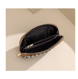 Detail of houndstooth clutch interior featuring card slots and a zipper compartment