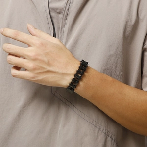Detail of a black industrial motorcycle chain bracelet on a wrist with a rugged metal finish