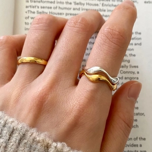 Minimalist 925 sterling silver rings with natural wave curve design on model's hand