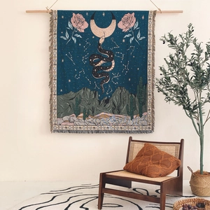 Bohemian woven tapestry featuring mystic snakes and moon motifs with elegant fringed edges