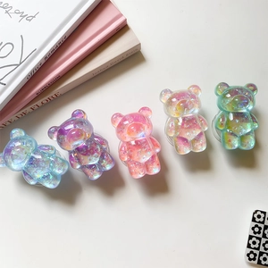 Close-up of five iridescent 3D bear phone sockets in pastel colors on a clean background