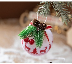 Detail of Christmas ornament featuring red reindeer print, pine cones and green needles