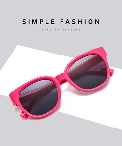 Close-up of rose pink matte round frame sunglasses with dark grey lenses in studio