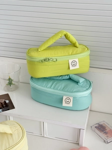 Colorful padded nylon cosmetic bags with smile labels and sturdy top handles for travel