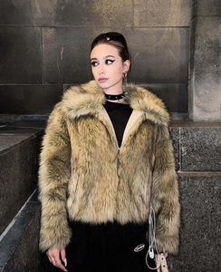 Detail shot of a short tan faux fur jacket with wide lapels and soft luxury texture