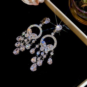 Détail des boucles d'oreilles papillon argentées avec pampilles en cristal scintillant