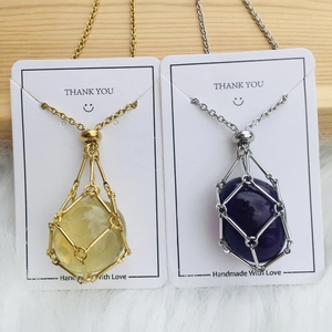 Natural crystal stone necklace in gold and silver bamboo metal net bag on wood background