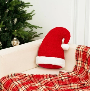 Coussin en forme de chapeau de Noël sur canapé avec sapin de Noël décoratif au fond