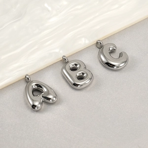 Macro shot of silver bubble letter A B C pendants in polished stainless steel