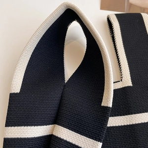Close-up of black and white geometric knit texture on a fashionable panda wrist bag