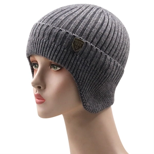 Close-up of dark grey ribbed knit beanie with vintage bronze shield logo and star emblem
