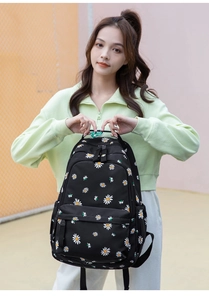 Close-up of lightweight nylon student backpack with white daisy pattern on black background