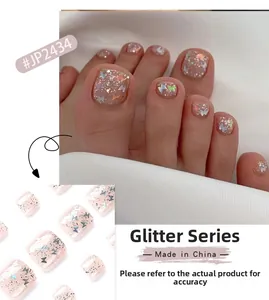 Detail of light pink press-on toenails with silver glitter and butterfly sequins