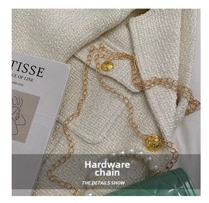 Close-up of mint green quilted silicone bag with gold chain and large pearl handle