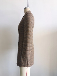 Gros plan sur la texture du tissu à carreaux pied-de-poule marron du blazer