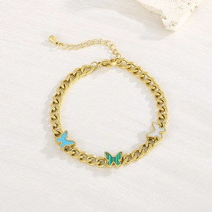 Detail of gold chain bracelet with green enamel butterflies and white stone decor