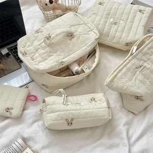 Detailed set of cream quilted storage bags with cute bunny embroidery in different sizes