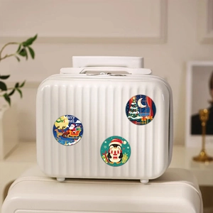 Autocollants de Noël sur une valise blanche dans un décor intérieur chaleureux et festif