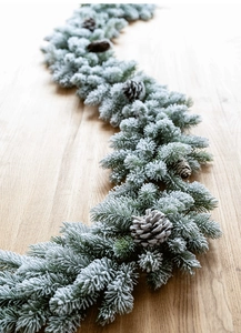 Vue détaillée d'une guirlande de Noël enneigée en PE avec pommes de pin sur bois