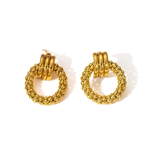 Detailed macro view of vintage gold earrings with textured round bead woven design