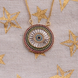 Macro shot of evil eye pendant necklace with colorful cubic zirconia and gold plating