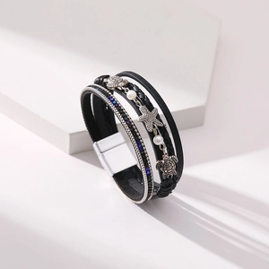 Detail of multi-layer leather bracelet with silver starfish, turtle charms and magnetic clasp