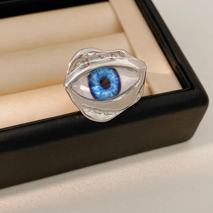 Macro shot of irregular silver ring with a realistic blue resin eye in a jewelry box