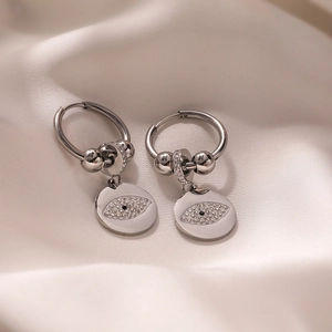 Silver devil's eye hoop earrings with crystal inlay on a premium white silk background