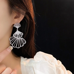 Modella che indossa orecchini a ventaglio a tre strati d'argento con strass lucidi