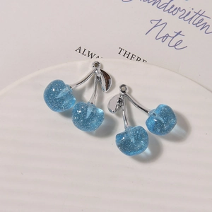 Detail view of blue glitter resin cherry pendants with silver stems for jewelry making