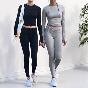 Close-up of slim fit high waist leggings and raglan sleeve yoga top on twin models