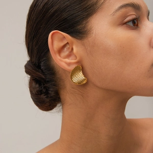 Macro detail of 18k gold crescent earrings featuring a unique fish scale texture pattern