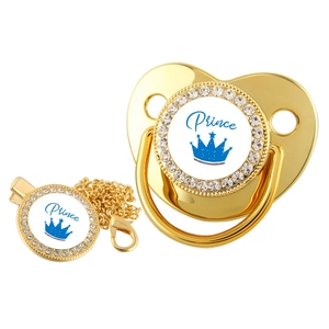 Close-up of golden crown pacifier with blue Prince text and sparkling rhinestones