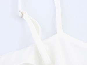 Detail of adjustable shoulder strap with silver buckle on white linen vacation dress