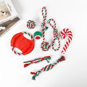 Detailed flat lay of 8-piece Christmas dog chew toy set in festive red, green and white colors
