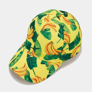 Close-up of tropical banana print baseball cap with vibrant yellow fabric and green leaves