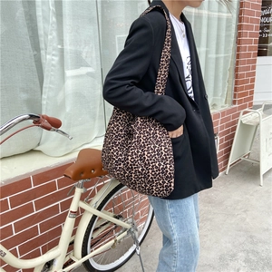 Outdoor view of a large leopard print canvas tote bag with a wide shoulder strap