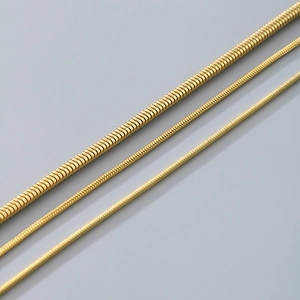 Detailed view of three gold snake chain bracelets in different thicknesses for men