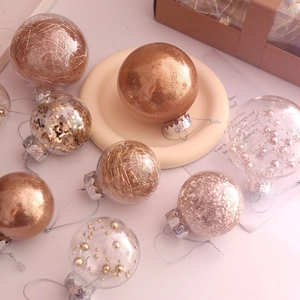 Close-up of 6cm clear Christmas ornaments with gold glitter and pearl fillings