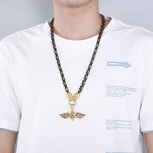 Close-up of model wearing gold winged skull pendant on a Byzantine chain necklace