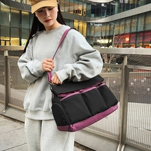 Close-up of a large black and purple nylon travel bag with multiple front pockets