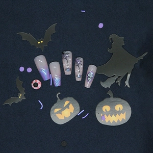 Detail view of Halloween spider web and skull press-on nails in purple and grey