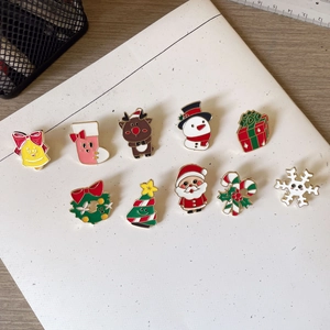 Detail of 10-piece Christmas enamel pins set with Santa and reindeer on white card