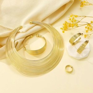 Macro shot of 4-piece gold jewelry set including choker, bracelet, earrings and ring