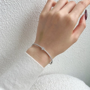 Macro detail of silver S925 heart bracelet with pavé cubic zirconia and central pear cut diamond