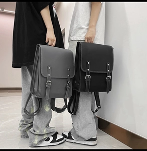 Gray and black minimalist leather backpacks shown by models for size comparison