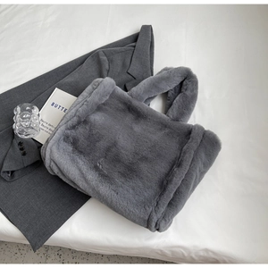 Detailed texture of grey plush faux fur tote bag with thick handles for winter style