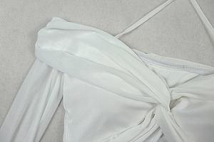 Close-up of white halter neck top with detailed mesh knit texture on neutral gray backdrop