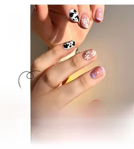 Detail of short square press-on nails with lavender borders, cow prints and daisy patterns